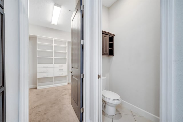 bathroom with tile patterned flooring, toilet, and baseboards