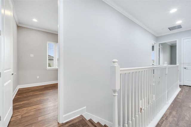 corridor featuring an upstairs landing, visible vents, crown molding, and wood finished floors