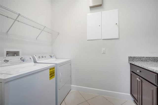 washroom featuring washer and clothes dryer, light tile patterned floors, cabinet space, and baseboards