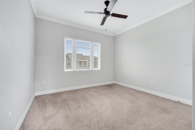 spare room with ceiling fan, light carpet, baseboards, and ornamental molding