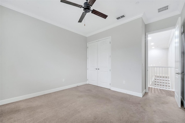 unfurnished bedroom with baseboards, carpet, visible vents, and ornamental molding