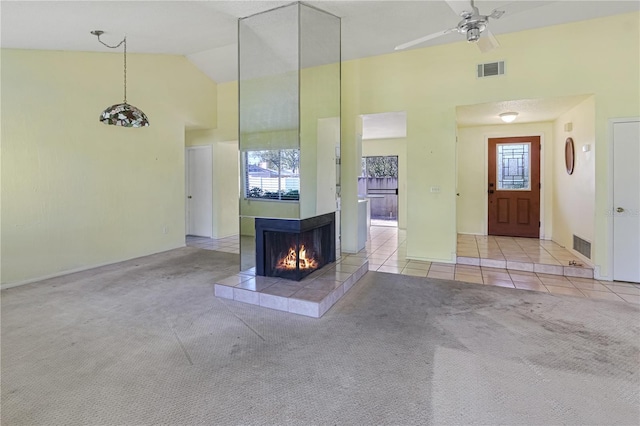 unfurnished living room with visible vents, carpet, a tile fireplace, and tile patterned flooring