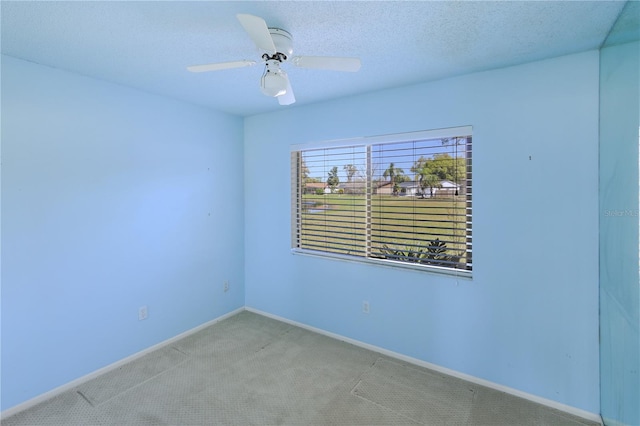 carpeted empty room with ceiling fan, baseboards, and a textured ceiling