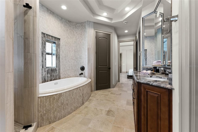 bathroom with vanity, stone tile floors, recessed lighting, a bath, and ensuite bath