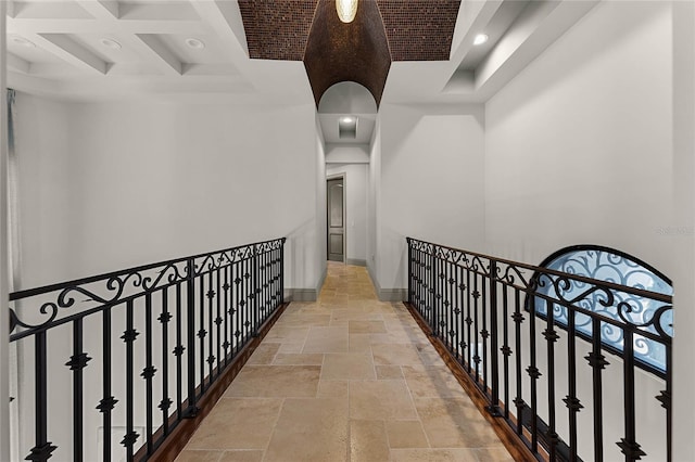 hallway featuring stone tile floors, baseboards, coffered ceiling, recessed lighting, and beamed ceiling