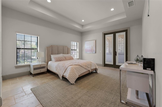 bedroom featuring access to exterior, visible vents, a raised ceiling, and baseboards