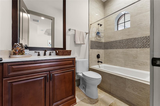 full bathroom with vanity, toilet, visible vents, and tiled shower / bath combo