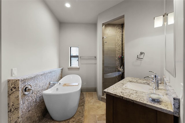 full bathroom featuring a sink, stone finish flooring, a shower stall, double vanity, and a soaking tub