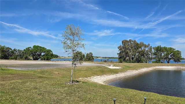 surrounding community with a water view and a yard
