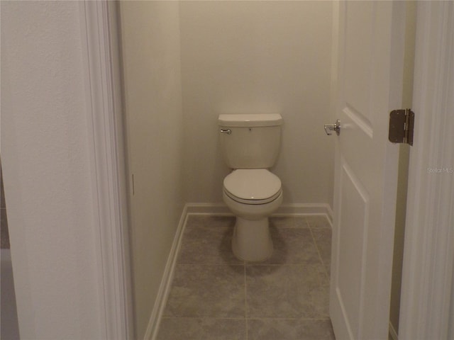 bathroom featuring toilet, tile patterned flooring, and baseboards