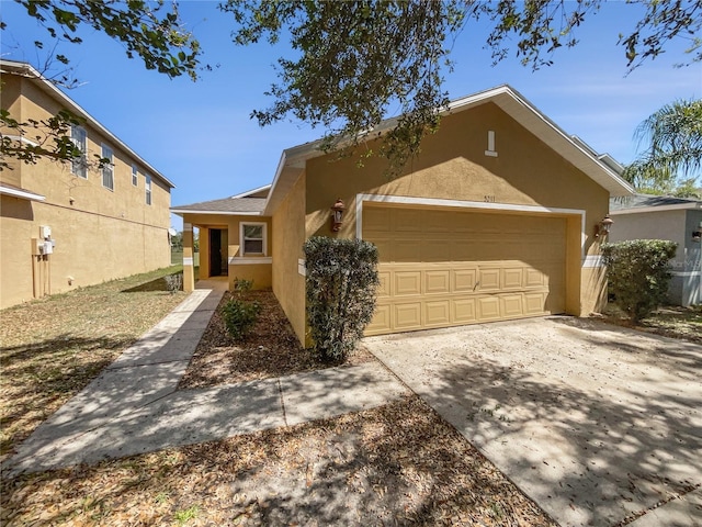 view of front facade featuring stucco siding, concrete driveway, and a garage