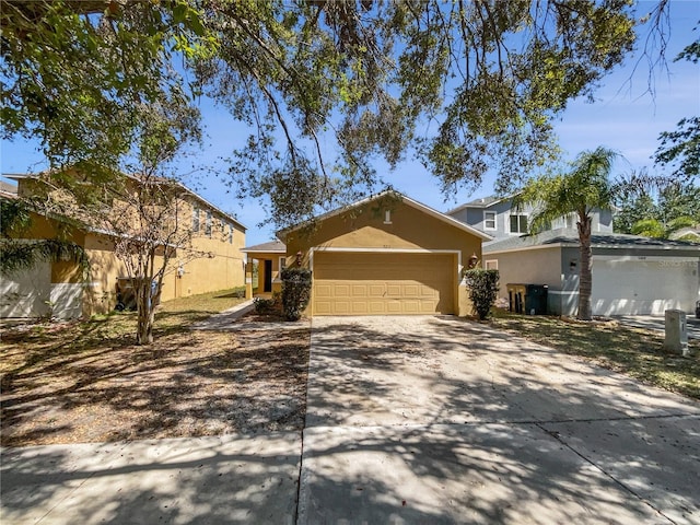 view of front of house featuring stucco siding, a garage, and driveway