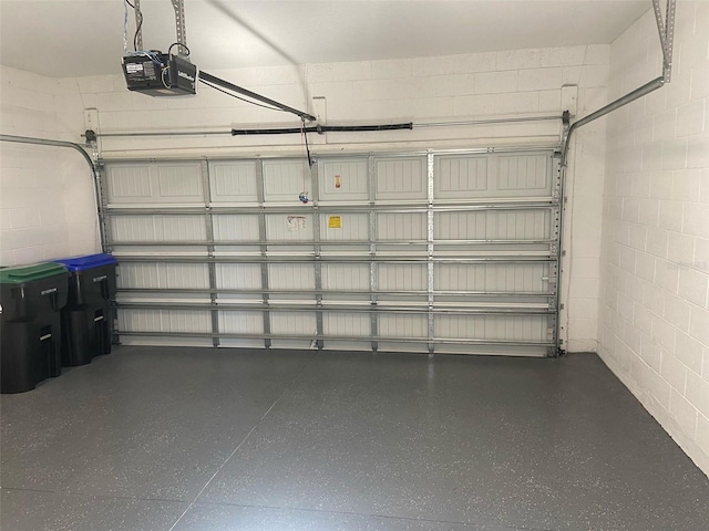 garage with concrete block wall and a garage door opener