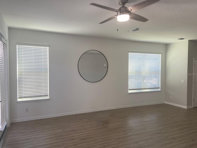 spare room featuring baseboards, wood finished floors, visible vents, and ceiling fan