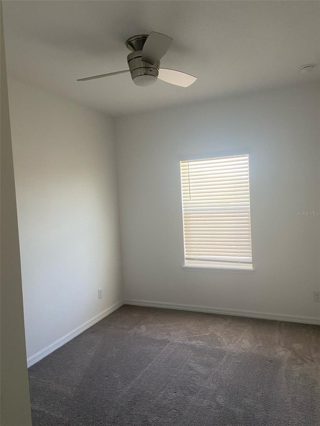 carpeted empty room featuring baseboards and ceiling fan