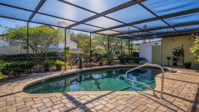 pool featuring glass enclosure and a patio area