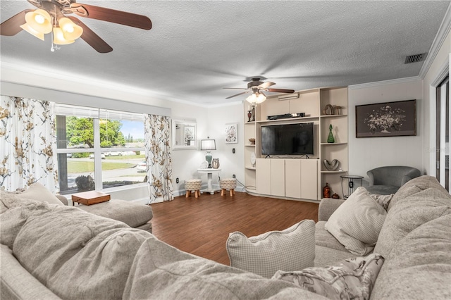 living area with wood finished floors, visible vents, ornamental molding, ceiling fan, and a textured ceiling