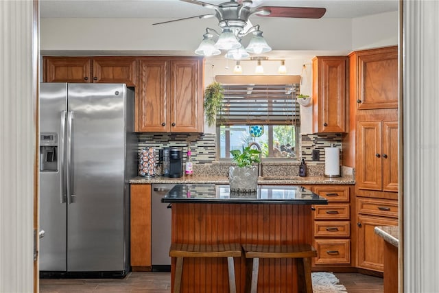 kitchen with stainless steel appliances, brown cabinets, and a ceiling fan