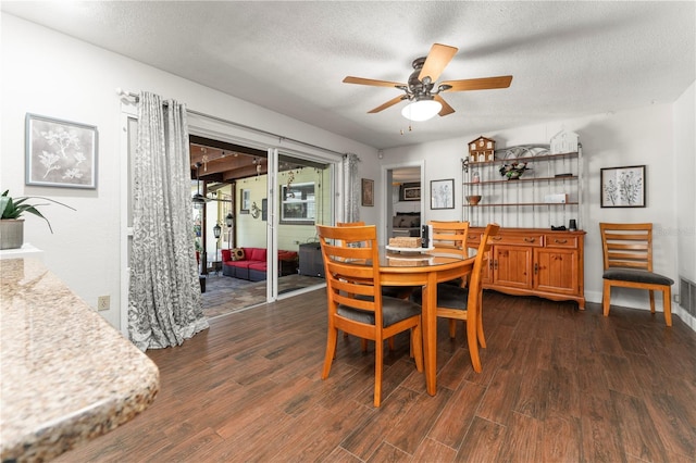 dining area with a textured ceiling, visible vents, dark wood-style flooring, and ceiling fan