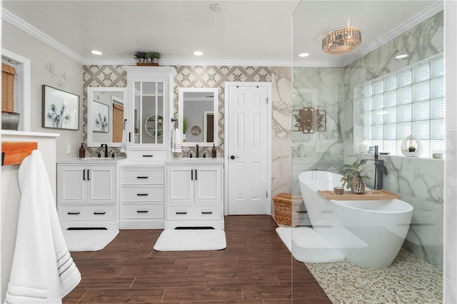 full bathroom featuring double vanity, a soaking tub, a sink, ornamental molding, and tile walls