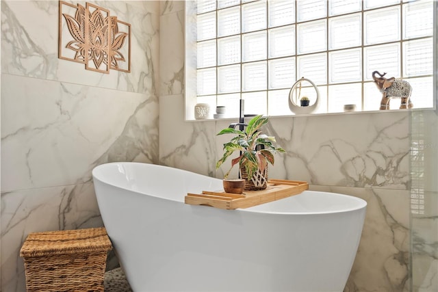 bathroom with tile walls and a freestanding tub