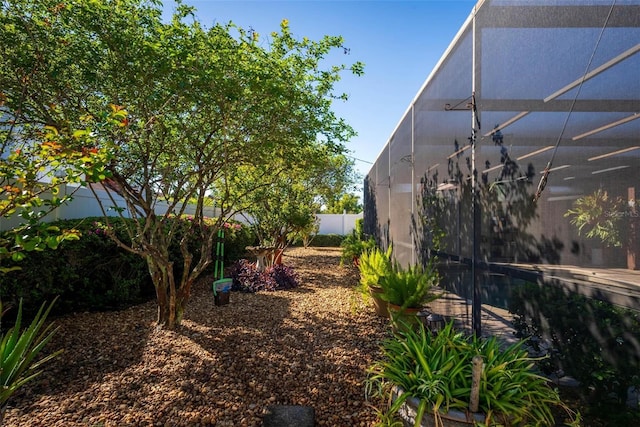 view of yard with a lanai and fence