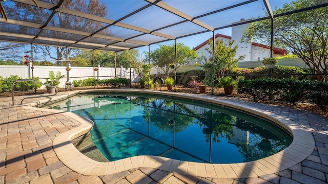 view of swimming pool with glass enclosure, a patio, a fenced backyard, and a fenced in pool