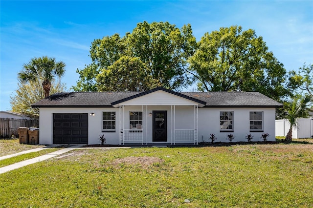 single story home with stucco siding, an attached garage, a front lawn, and fence