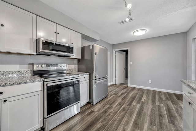 kitchen with visible vents, dark wood-style flooring, appliances with stainless steel finishes, a textured ceiling, and white cabinetry