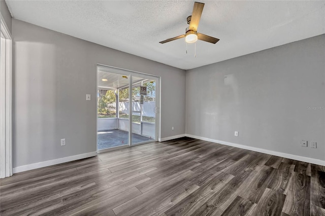 empty room with a ceiling fan, baseboards, a textured ceiling, and dark wood-style flooring