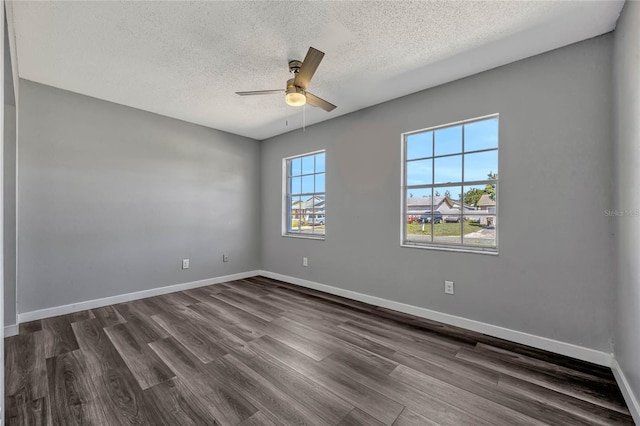 unfurnished room featuring dark wood-type flooring, baseboards, a wealth of natural light, and ceiling fan