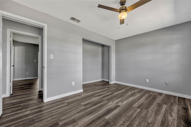 unfurnished bedroom with a ceiling fan, visible vents, baseboards, dark wood finished floors, and a closet