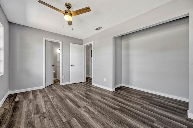 unfurnished bedroom with dark wood-type flooring, baseboards, visible vents, and a textured ceiling