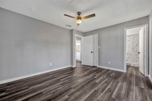 unfurnished bedroom with visible vents, baseboards, a textured ceiling, and dark wood-style floors