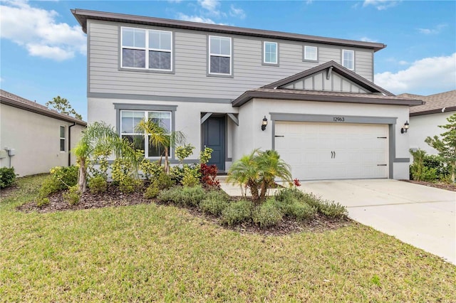 view of front of home with a garage, a front yard, driveway, and stucco siding