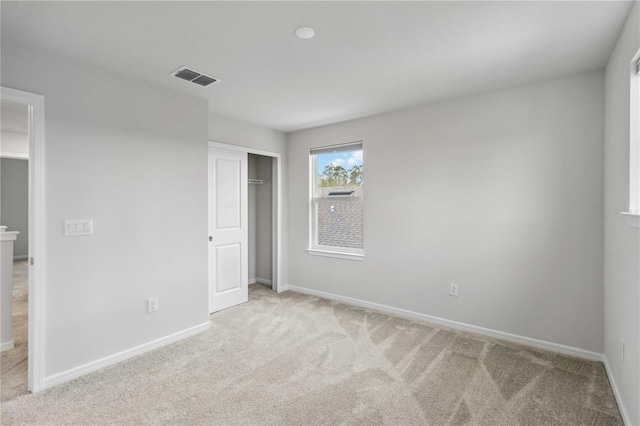 unfurnished bedroom with a closet, visible vents, baseboards, and carpet floors