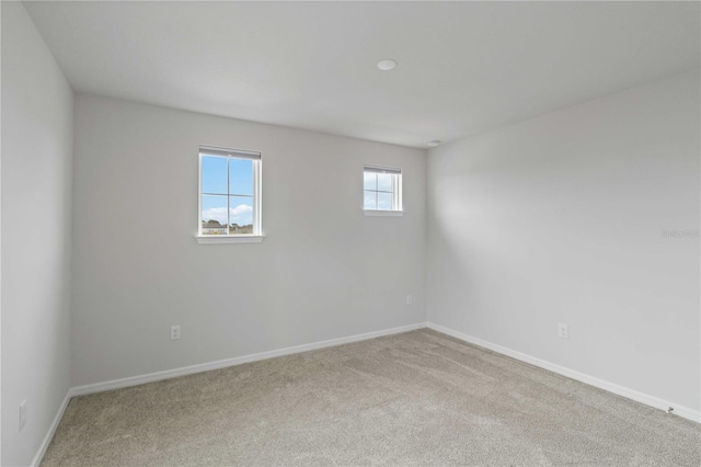 carpeted empty room with baseboards