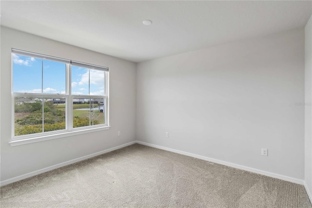 empty room featuring baseboards and carpet