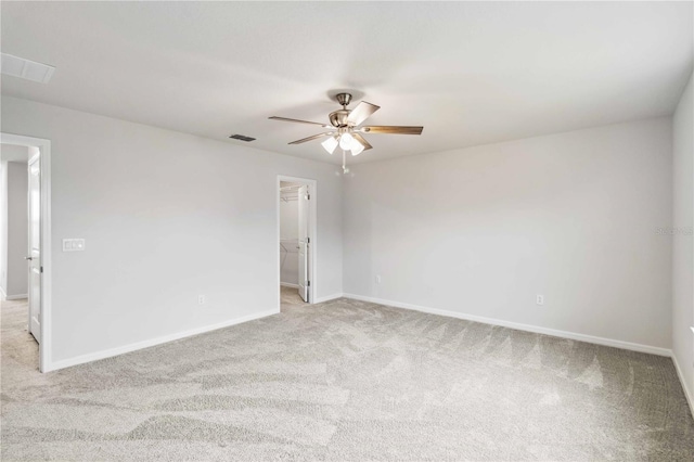 empty room featuring ceiling fan, baseboards, visible vents, and light carpet