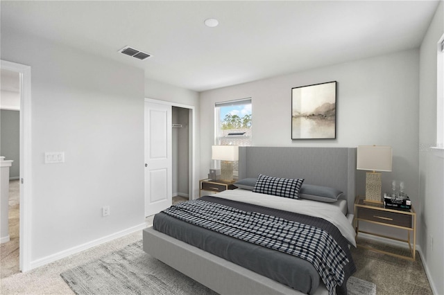 carpeted bedroom featuring baseboards, visible vents, and a closet