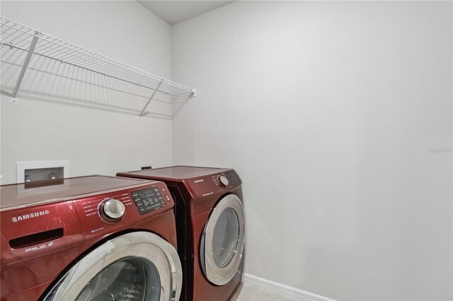 clothes washing area with washer and clothes dryer, laundry area, and baseboards