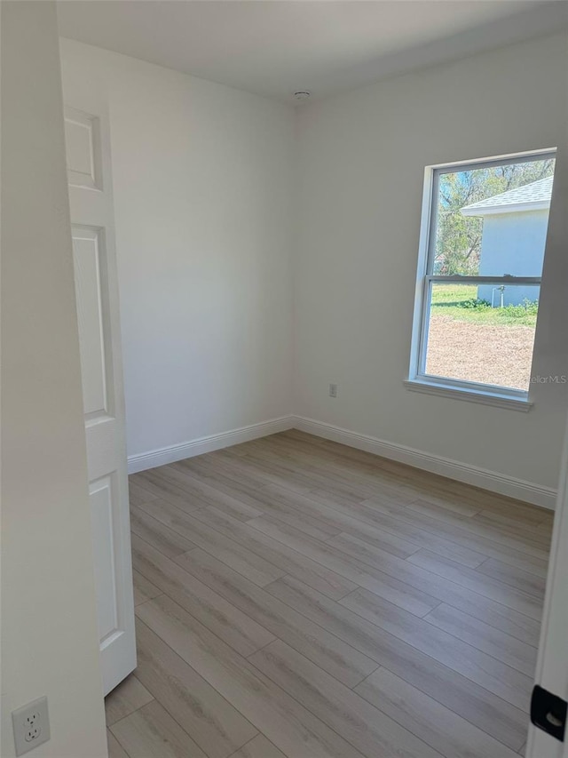 spare room with light wood-style floors and baseboards