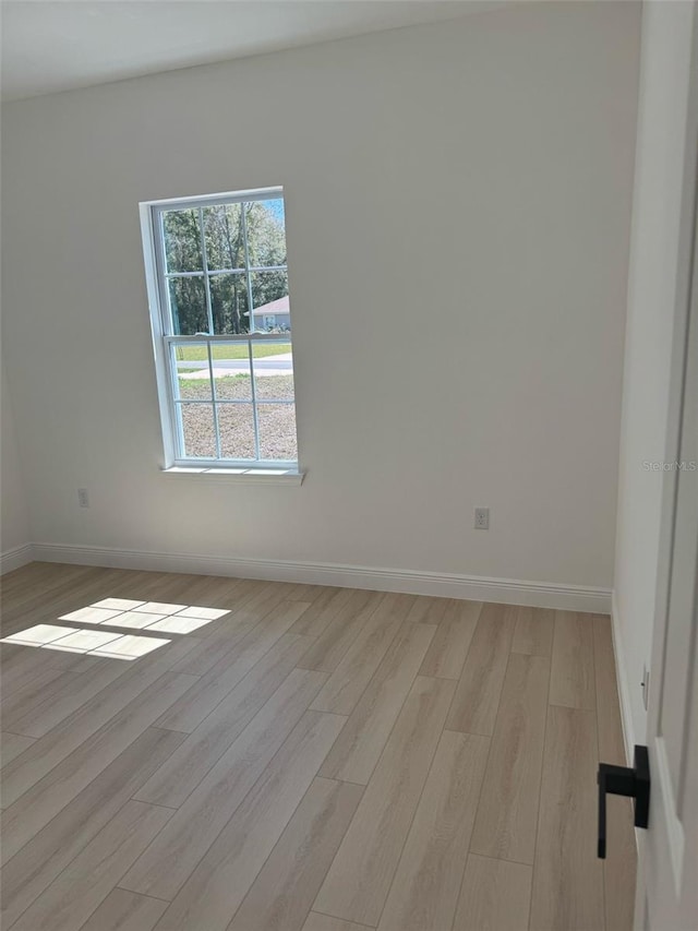 unfurnished room featuring light wood finished floors and baseboards