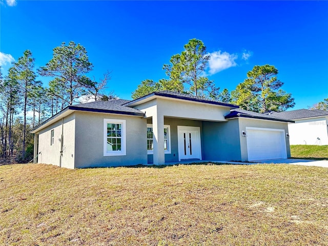 view of front of home featuring a front lawn, an attached garage, driveway, and stucco siding