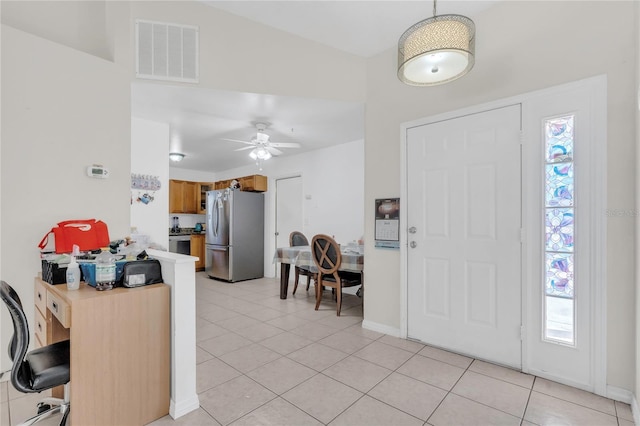 foyer featuring light tile patterned floors, baseboards, visible vents, and ceiling fan