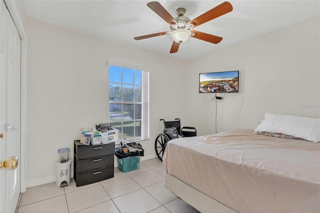 bedroom featuring light tile patterned floors, baseboards, and ceiling fan