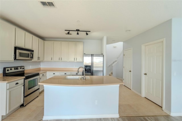 9620 Doris Ln, Orlando, FL 32829 - kitchen with appliances with stainless steel finishes, a sink, an island with sink, light countertops, and light tile patterned flooring
