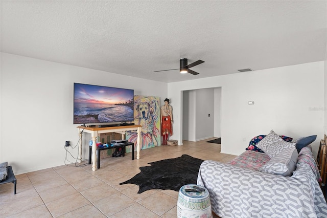 living area with visible vents, a textured ceiling, ceiling fan, and light tile patterned flooring