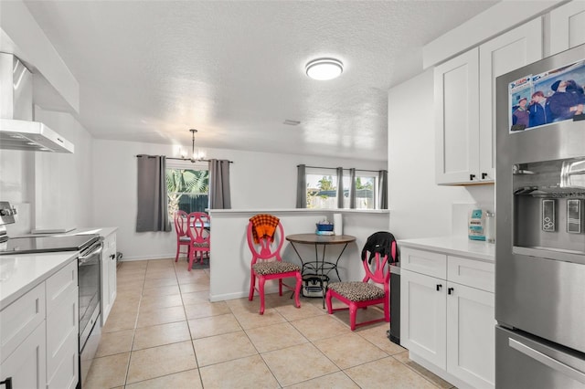 kitchen with appliances with stainless steel finishes, a healthy amount of sunlight, light countertops, and wall chimney range hood