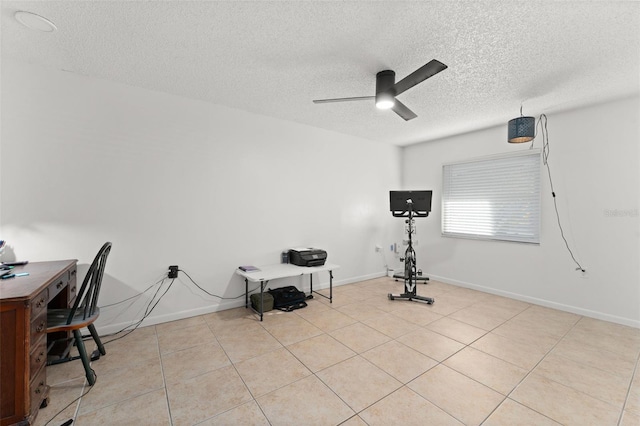 workout area with baseboards, a textured ceiling, ceiling fan, and light tile patterned flooring